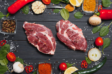 Raw pork meat on wooden cutting board at kitchen table for cooking pork steak roasted or grilled with ingredients herb and spices , Fresh pork
