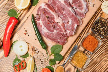 raw meat with fresh vegetables and spices on wooden background. Top view. Free space for text. prepare yourself concept