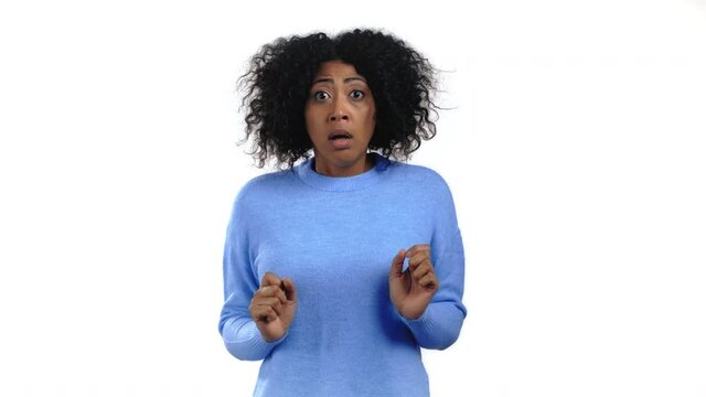 Portrait of african unpleasantly surprised and shocked girl on white studio background. Woman receiving bad news. She expresses sympathy and regret.