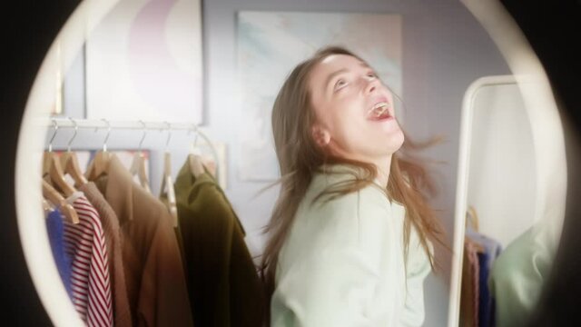 Girl take a selfie on a phone in room with tripod lamp selfie stick, student dance and sign in front of camera, use mask application film maker and streaming happy blogger fun activity challenge