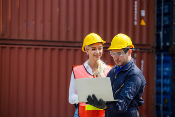 Foreman is using the laptop to check the layout and planning the location of the container. Young female is looking and suporting him to communicate with the worker.