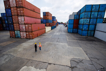 Foreman point the container to move the location. Female logistic staff using radio to communicate...