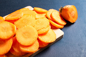 Tasty carrot slices arranged on a wooden board. Vegetables prepared for serving in home cooking.