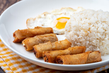 Shanghaisilog  (side shot without cutlery)- is a famous Filipino meal that consists of fried rice, egg and spring rolls.
