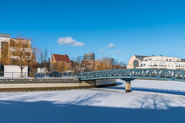Frozen Harbor basin Tegeler Hafen with the footbridge and the clinic Medical Park Humboldtmuehle in Berlin, Germany