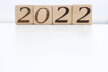 Wooden blocks with the numbers 2022 on a white surface in the open air.