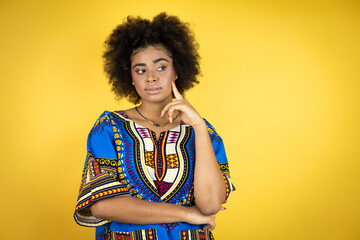 African american woman wearing african clothing over yellow background