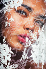 portrait of beauty young afro woman through white lace, like new bride under veil close up