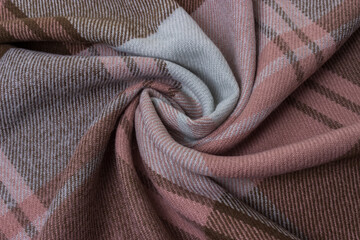 The fabric is in brown, pink and mint shades, twisted in a spiral.