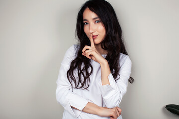 young asian woman doctor in white uniform gesturing positive on gray background, lifestyle healthcare people concept