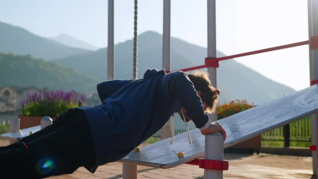 push-up outdoor in open sport area, man is training