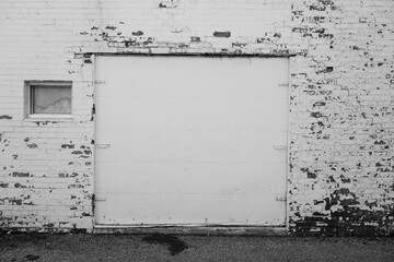 Black and white grungy garage door with weathered brick