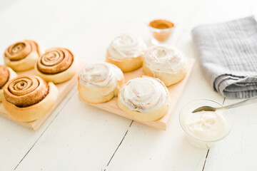 Cinnamon rolls with white icing on a wooden table