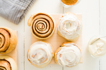 Flat lay of baked sweet rolls decorated with white icing