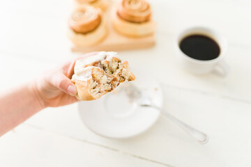 Female hand holding a homemade cinnamon roll