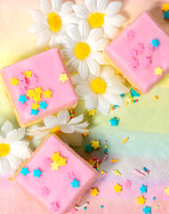 Cakes with pink icing and colourful sprinkles