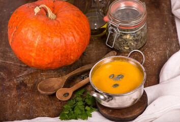 Bowl of pumpkin soup on rustic wooden background