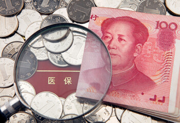 A magnifier with china yuan on the background of medical insurance bankbook