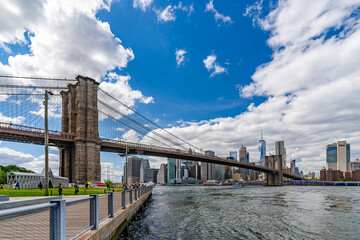 Wide angle view Brooklyn Bridge with lower Manhattan skyline, One World Trade Center Empire Fulton Ferry Park