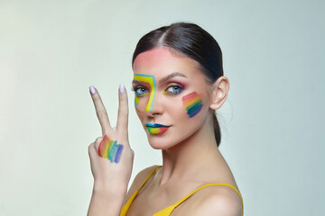 Obraz na płótnie Canvas portrait of an attractive girl with bright makeup. A rainbow LGBT flag is depicted on her cheek