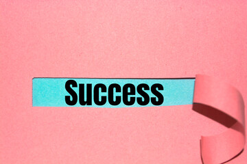 Text Success appearing behind ripped brown paper