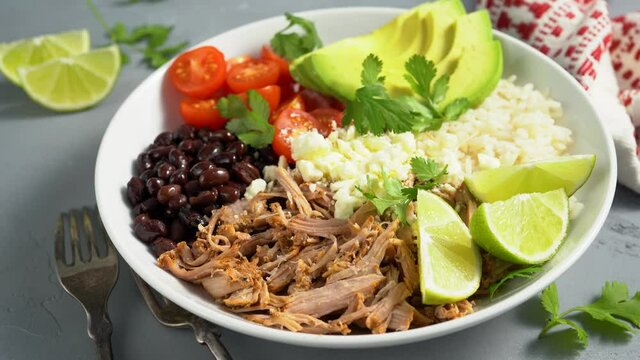 Pork carnitas bowl or burrito bowl with rice, tomatoes and avocado