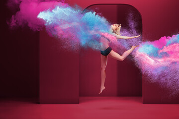 Young woman doing high jump inside of cloud of powder
