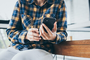 using cell phone hand holding mobile texting message contact us.chatting,search internet information in office.technology device communication connecting