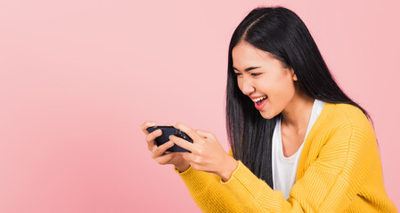 Happy Asian portrait beautiful cute young woman teen smiling excited   using mobile phone say yes!...