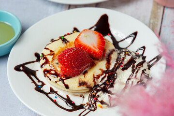 Pancakes with maple syrup in plate on white background