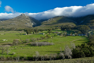 Clouds hover on the hilltops above a farm on the Western Cape, South Africa