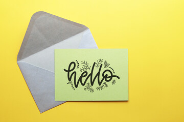 Top view of grey envelope with Hello greeting card