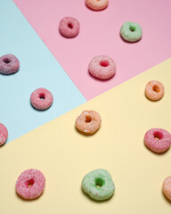 Donuts with different isolated colors on blue, yellow and pink background. Delicious snacks suitable to be eaten in spare time. Practical mini donuts to carry wherever you are. Sweet donuts.