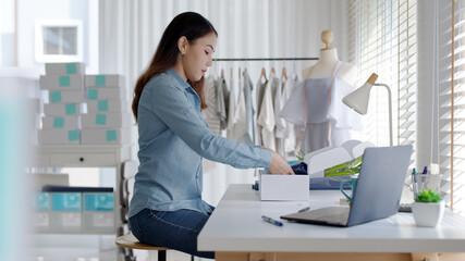 Young attractive beautiful hipster asia female packing product small business parcel order online retail store for delivery to customer. SME owner work preparing dropshipping box at home office.