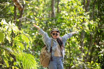 woman spread arms in the middle of a high trees nature forest