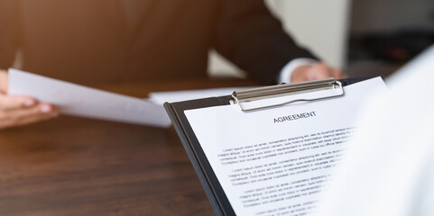 Businessman holds signs agreement contract on the table.