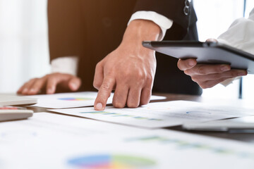 Businessman holding tablet and using laptop with brainstorming in planning work.