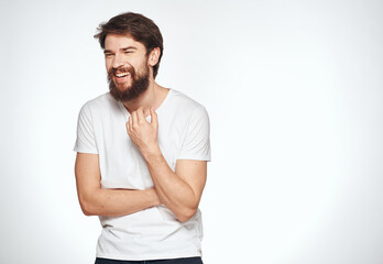 Emotional guy in a white t-shirt on a light background emotions model cropped view of a student