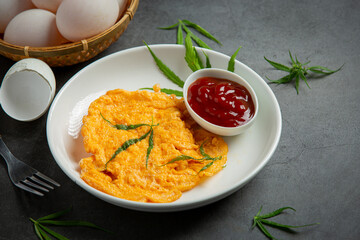 Egg omelet with marijuana leafs on old dark background