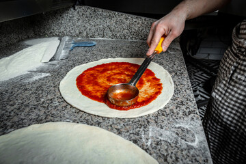 Fresh original Italian raw pizza, preparation in traditional style. Restaurant chef takes pizza...