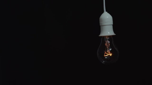Light bulb flickering swings in the dark
