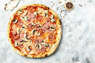 Tasty Capriciosa pizza. Classic pizza with ham and mushrooms on a light background, top view. Italian pizza is cooked in a wood-fired oven