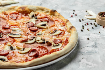 Capriciosa. Classic pizza with ham and mushrooms on a light background, top view. Traditional Italian pizza