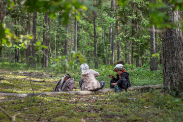 Brother and sister resting while hiking in the woods