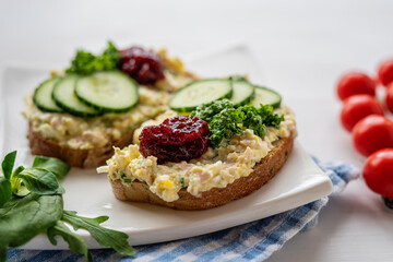 sandwich dip bread spread with salad vegetables on white porcelain plate 