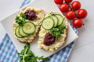 sandwich dip bread spread with salad vegetables on white porcelain plate 