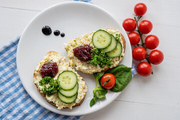 sandwich dip bread spread with salad vegetables on white porcelain plate 