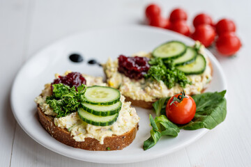 sandwich dip bread spread with salad vegetables on white porcelain plate 