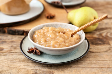 Bowl of tasty pear jam on wooden table