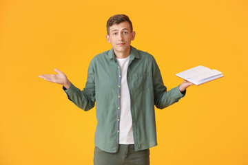 Worried man with red book on color background